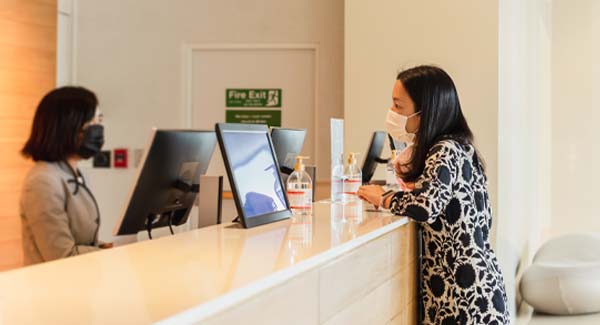 woman speaking to receptionist