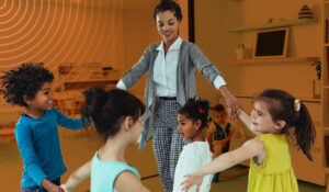 A woman leading children in a game at a daycare