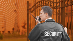 Male security guard with portable radio, outdoors