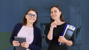 Two women, a teacher and administrator, walk through a school hallway discussing best practices for back-to-school safety