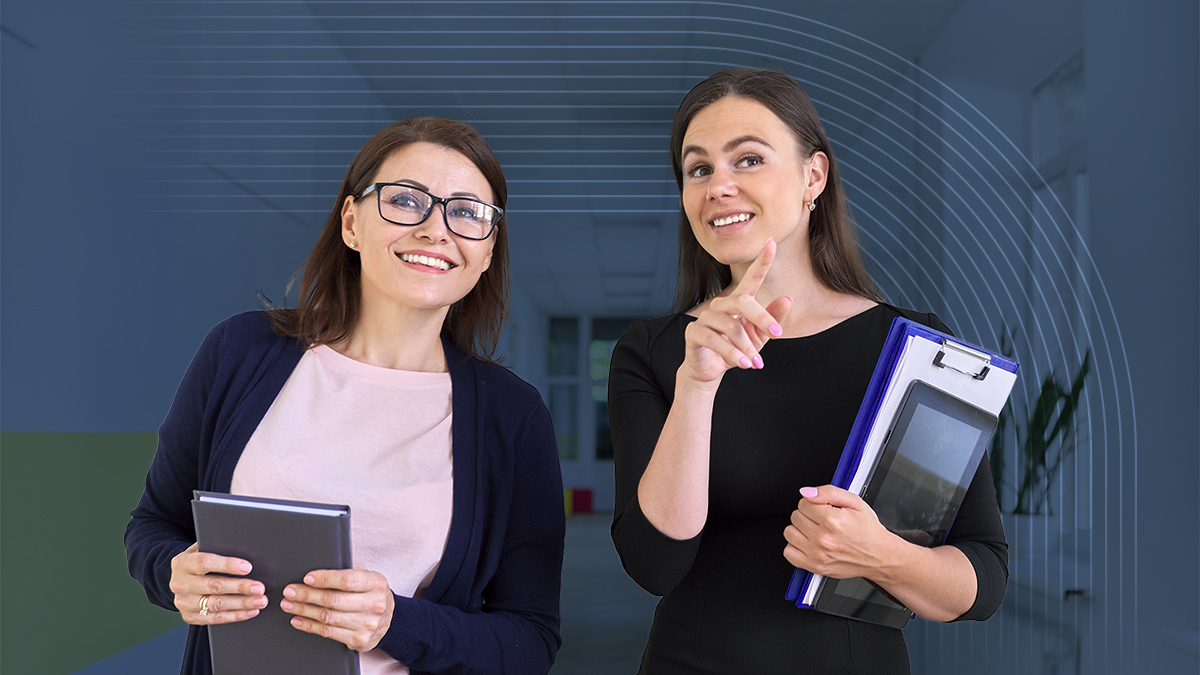 Two women, a teacher and administrator, walk through a school hallway discussing best practices for back-to-school safety