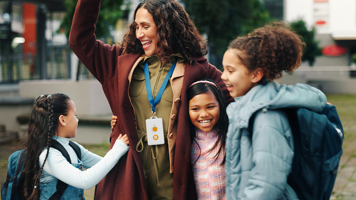 A campus administrator greets young students to build connections that help prevent bullying