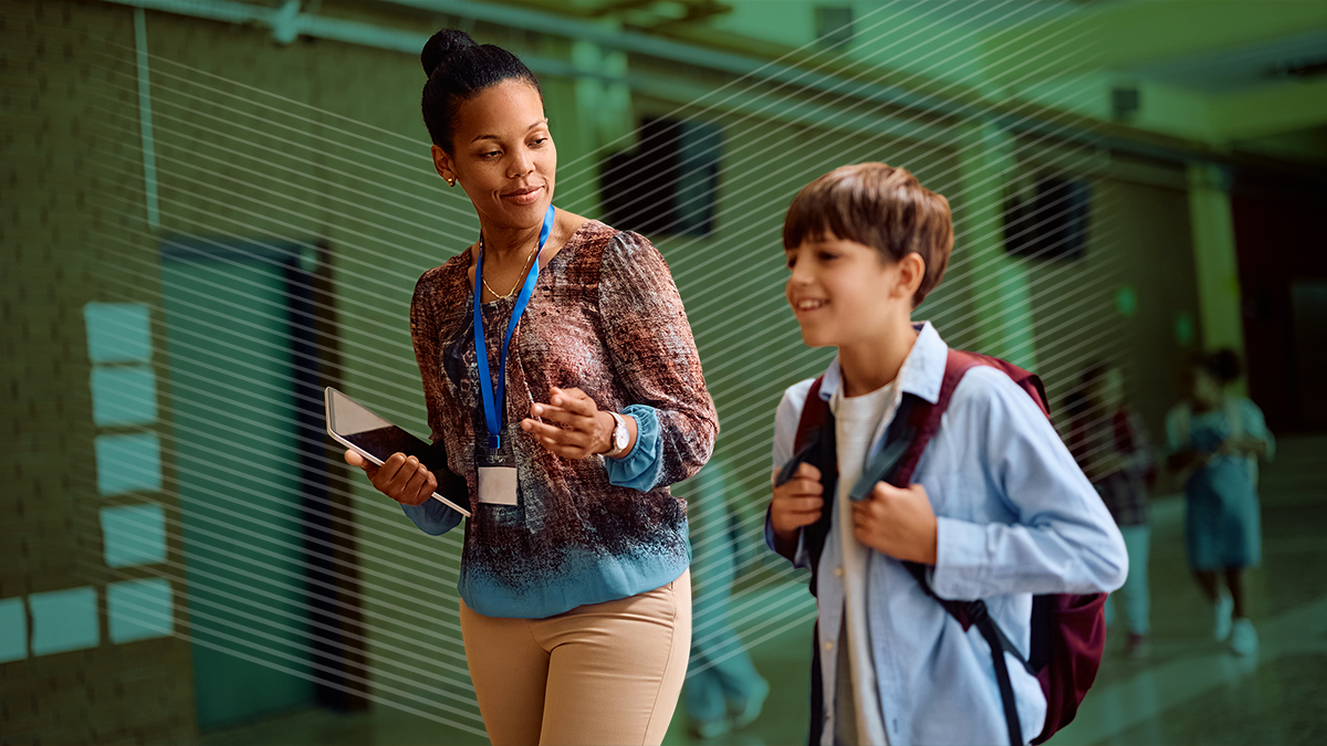 A teacher escorts a student in a hallway, showing how traditional hall passes are needed for students with IEPs.